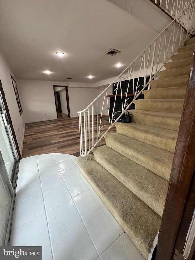 stairway with recessed lighting, visible vents, and tile patterned floors