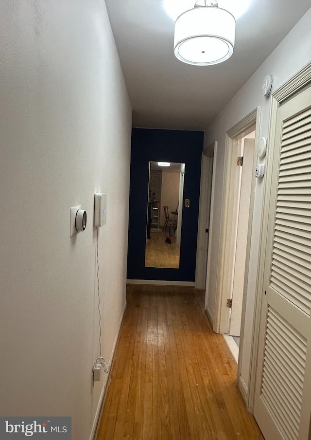 hall featuring light wood-style floors and baseboards