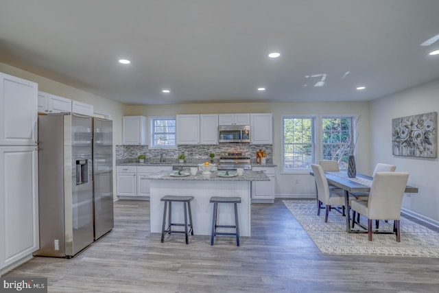 kitchen with stainless steel appliances, white cabinets, and a center island