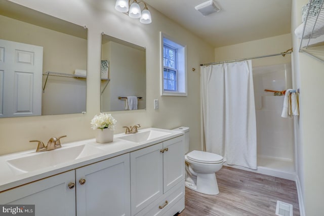 bathroom featuring a shower with curtain, dual bowl vanity, toilet, and hardwood / wood-style flooring