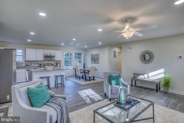 living room with ceiling fan and light hardwood / wood-style flooring