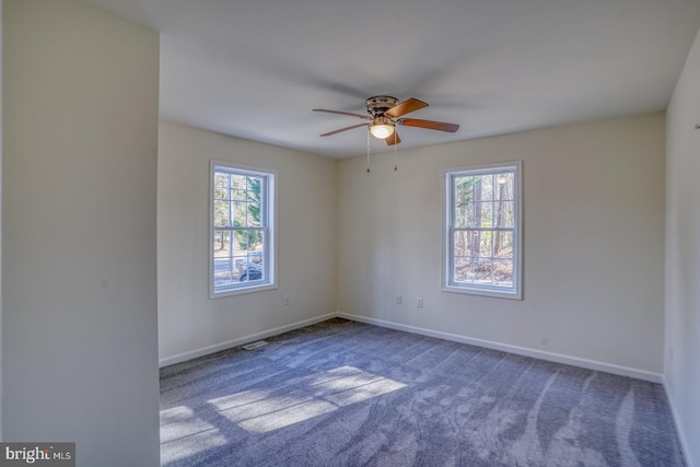 spare room with ceiling fan, a healthy amount of sunlight, and carpet flooring