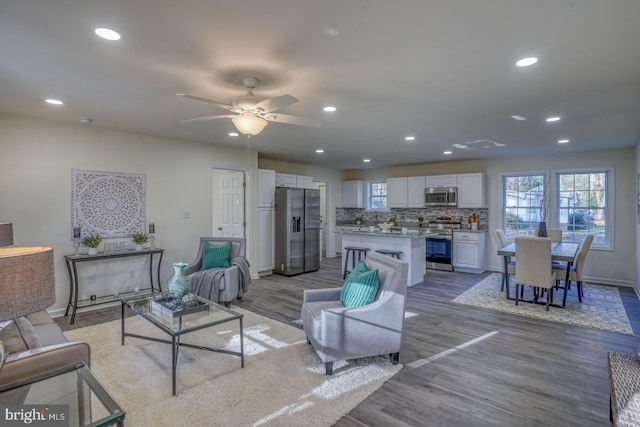 living room featuring ceiling fan and light hardwood / wood-style flooring