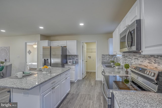 kitchen featuring white cabinets, backsplash, and stainless steel appliances