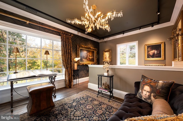 interior space with a notable chandelier, wood-type flooring, crown molding, and track lighting