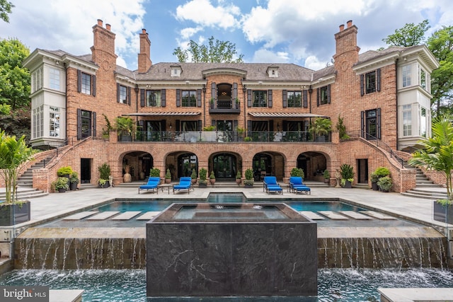 view of swimming pool featuring an in ground hot tub, pool water feature, and a patio area