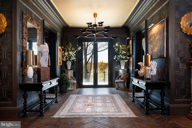 entryway with an inviting chandelier, parquet floors, a textured ceiling, and ornamental molding