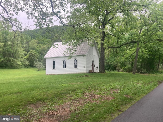 view of side of home with a yard