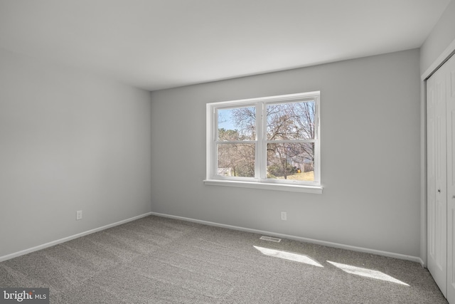 unfurnished bedroom with a closet and carpet flooring