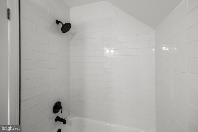 interior details featuring tiled shower / bath combo