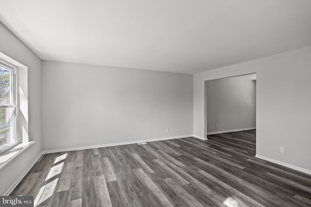 unfurnished room with dark wood-type flooring