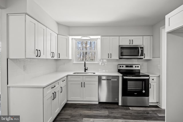 kitchen featuring stainless steel appliances, dark wood-type flooring, sink, and white cabinetry