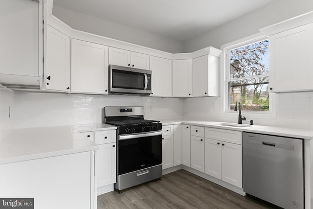 kitchen with sink, dark wood-type flooring, tasteful backsplash, and appliances with stainless steel finishes