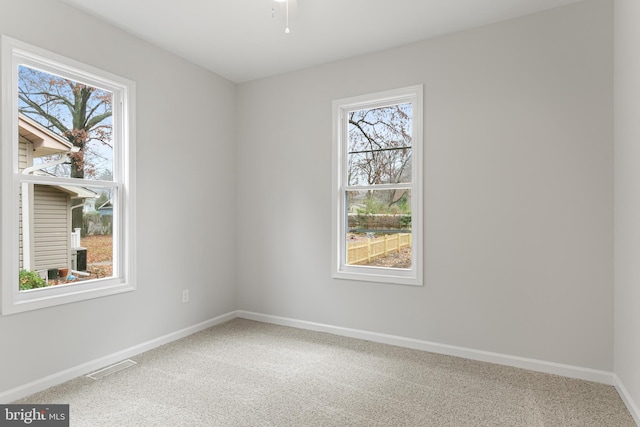 carpeted spare room featuring plenty of natural light