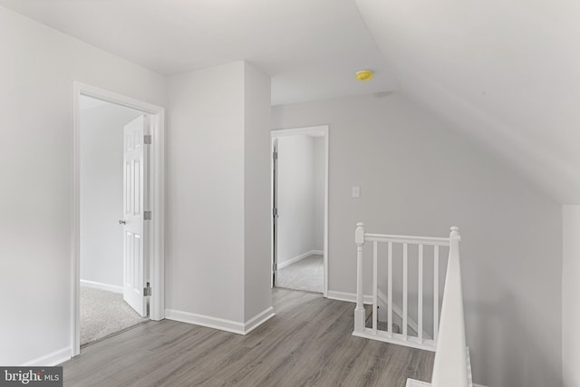 additional living space with hardwood / wood-style flooring and vaulted ceiling