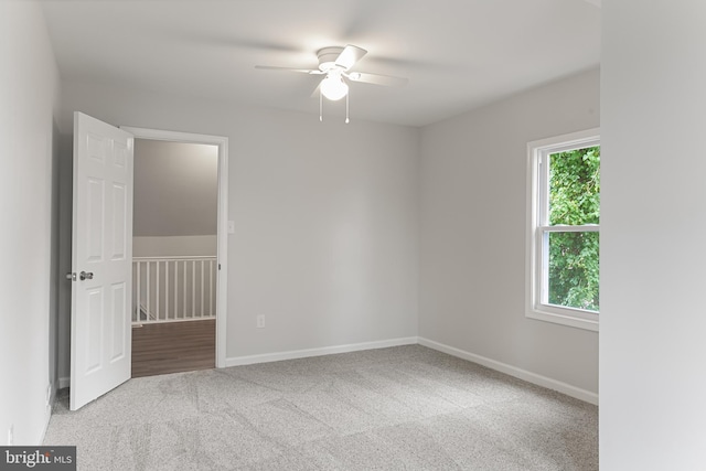 carpeted spare room with ceiling fan