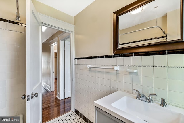 bathroom with vanity, hardwood / wood-style flooring, and tile walls