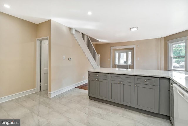 kitchen with gray cabinetry, a wealth of natural light, and dishwasher