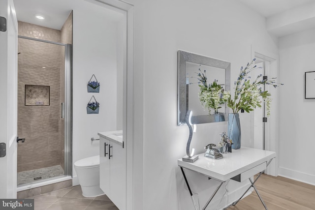 bathroom with vanity, toilet, and a shower with shower door