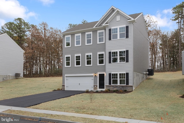 view of front of house with central air condition unit, a front lawn, and a garage