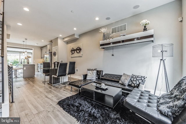 living room featuring a notable chandelier and light wood-type flooring