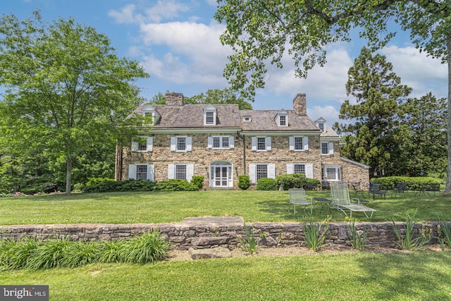 rear view of property featuring a lawn