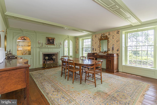 dining room with a wealth of natural light, ornamental molding, and hardwood / wood-style flooring