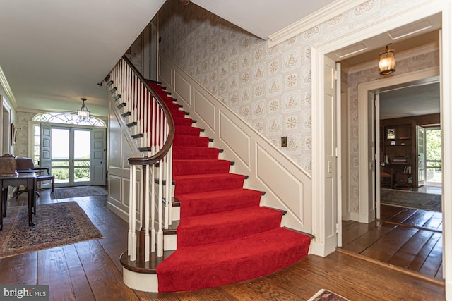 staircase with crown molding, french doors, and dark hardwood / wood-style floors