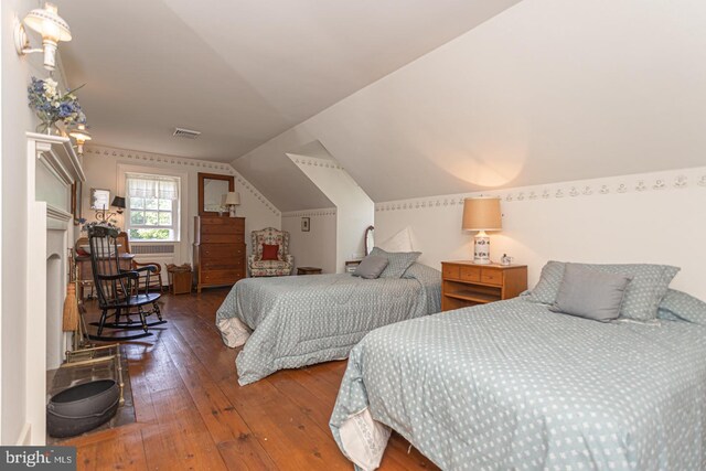 bedroom with vaulted ceiling and hardwood / wood-style flooring