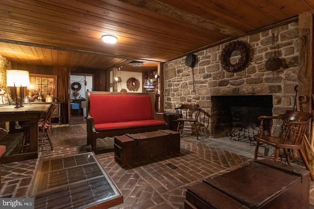 living room with wooden ceiling and a stone fireplace