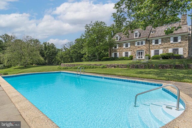 view of swimming pool featuring a yard