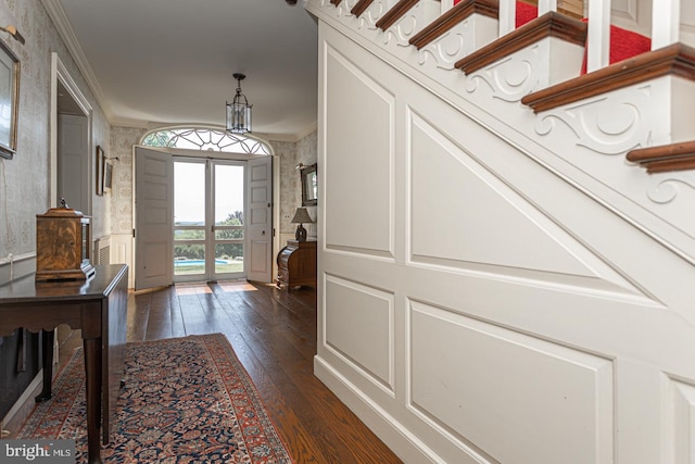 entrance foyer with dark hardwood / wood-style flooring and ornamental molding