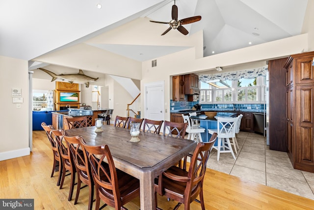 dining room featuring ceiling fan, vaulted ceiling, and light hardwood / wood-style flooring