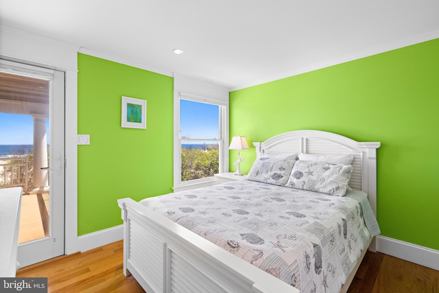 bedroom with crown molding and light wood-type flooring