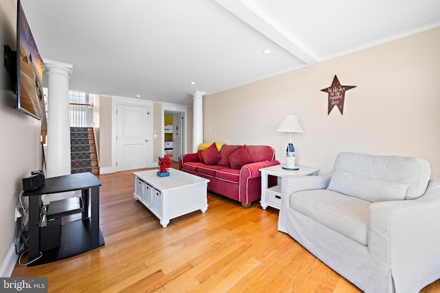 living room featuring beamed ceiling, decorative columns, and light hardwood / wood-style flooring