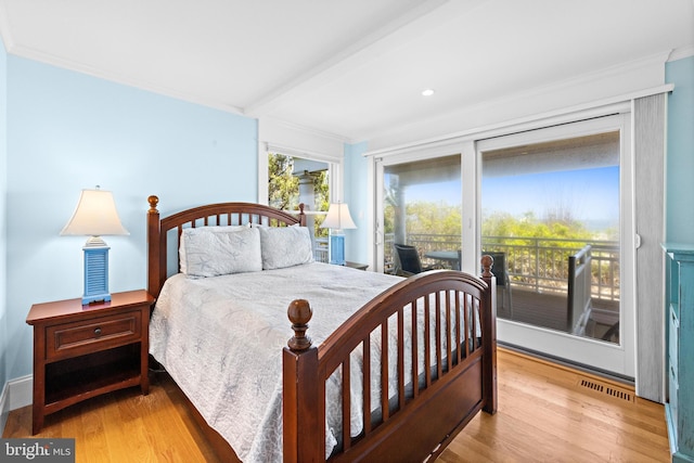 bedroom featuring beam ceiling, light hardwood / wood-style floors, access to outside, and crown molding