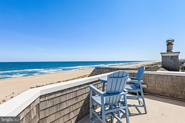 view of terrace featuring a view of the beach and a water view