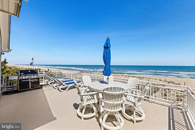 view of terrace with area for grilling, a beach view, and a water view