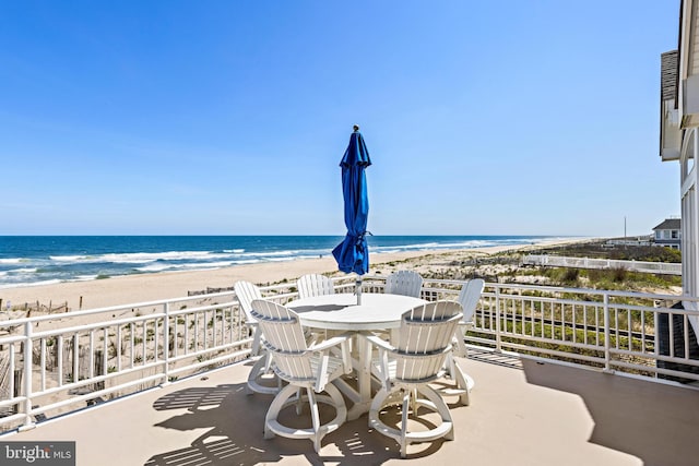 view of patio with a beach view and a water view