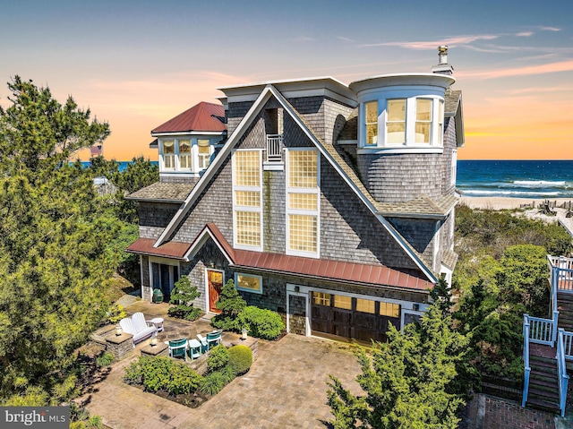 view of front of house with a garage and a water view