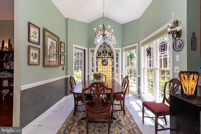 dining room with an inviting chandelier, plenty of natural light, and lofted ceiling