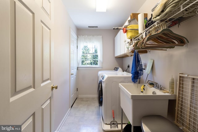 laundry room featuring cabinets, washing machine and dryer, and sink