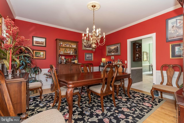 dining space featuring a notable chandelier, light wood-type flooring, and ornamental molding