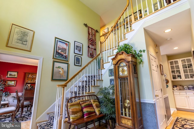 stairway with a high ceiling and hardwood / wood-style flooring