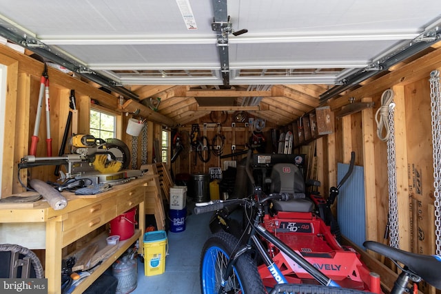 garage with a workshop area and wooden walls