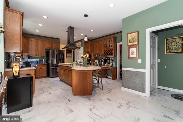 kitchen with island range hood, a kitchen breakfast bar, stainless steel fridge, decorative light fixtures, and a kitchen island