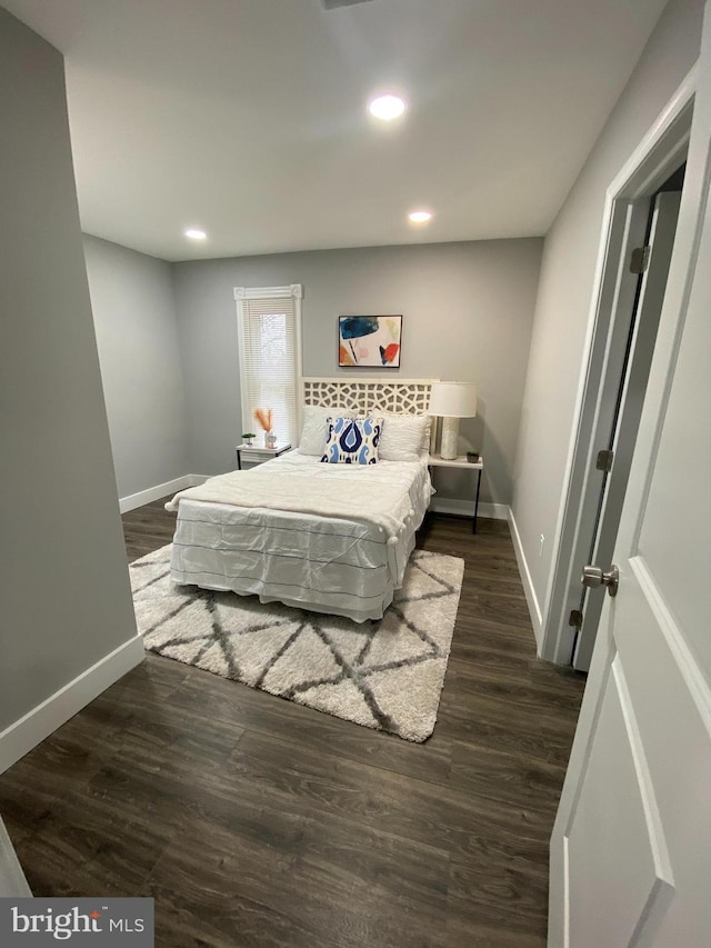 bedroom with dark hardwood / wood-style floors