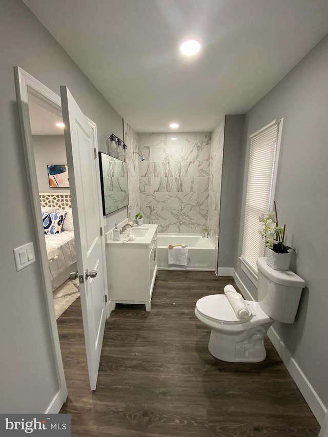 full bathroom featuring vanity, toilet, wood-type flooring, and tiled shower / bath combo