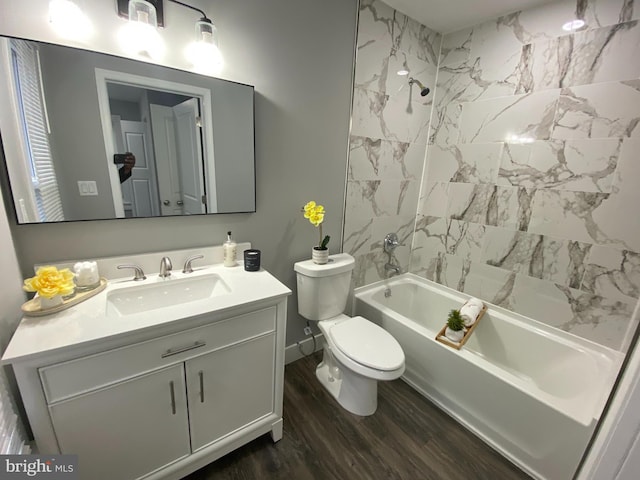 full bathroom with vanity, hardwood / wood-style floors, tiled shower / bath combo, and toilet