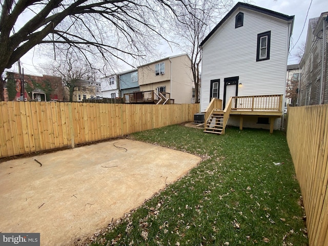 rear view of property featuring a yard, a patio area, and a wooden deck